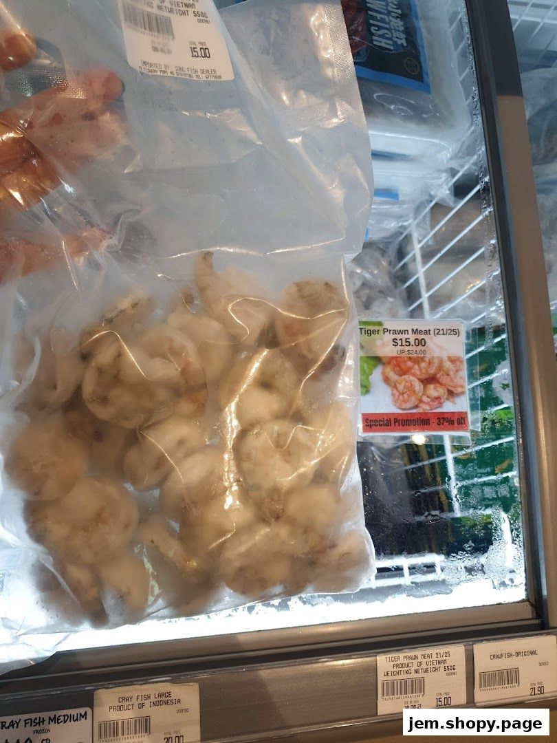Frozen seafood products, including tiger prawn meat and cray fish, displayed in a refrigerated case.