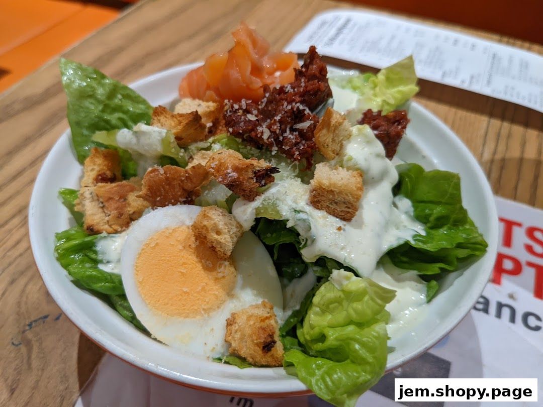 A close-up of a delicious Caesar salad with smoked salmon, egg, and croutons.