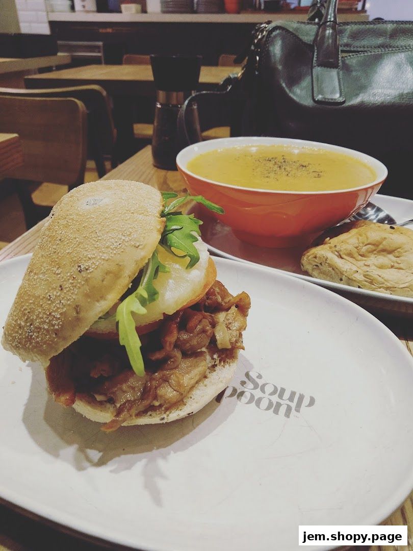 A delicious soup and sandwich meal served on a plate with the shop's logo.