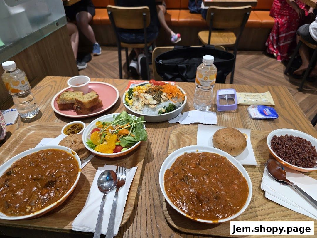A table laden with various dishes from The Soup Spoon, including stews, salads, and bread.