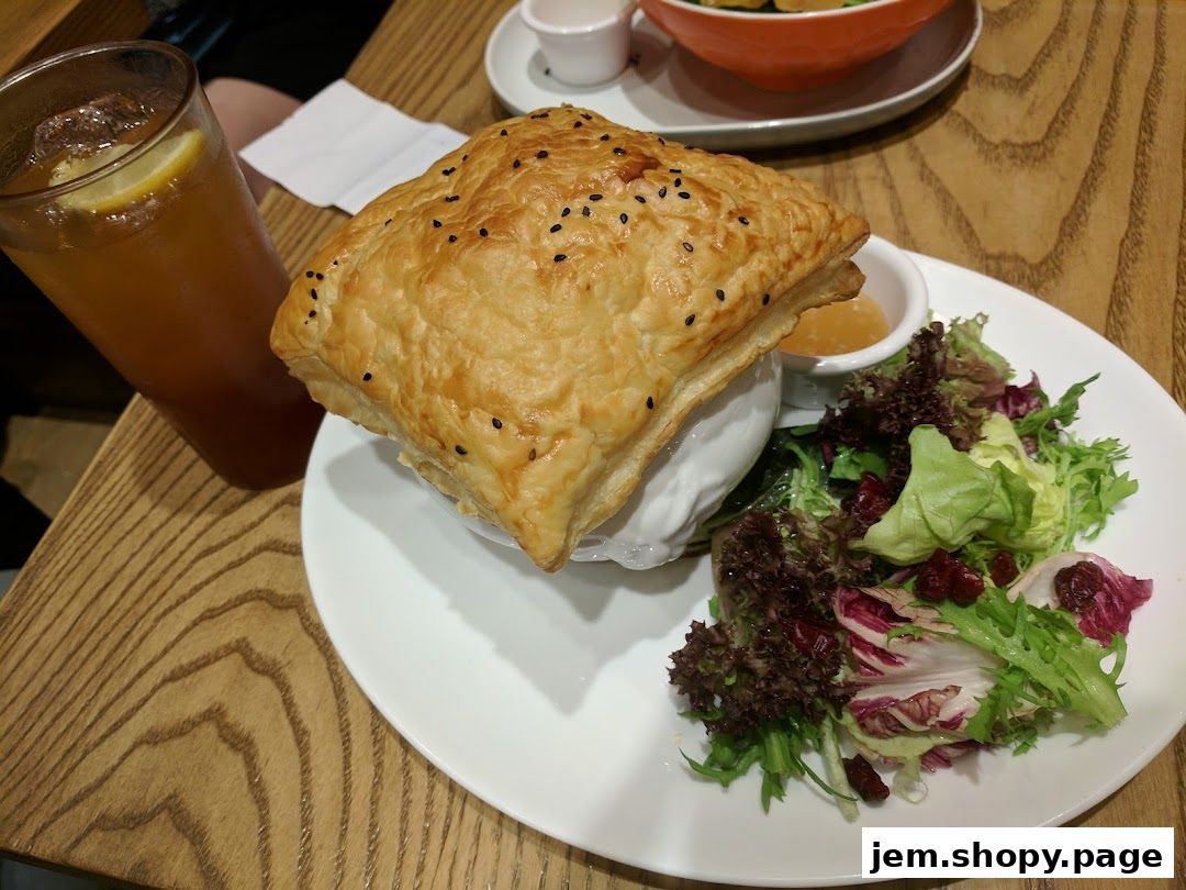 A savory pie with a golden crust, served with a side salad and a refreshing drink.