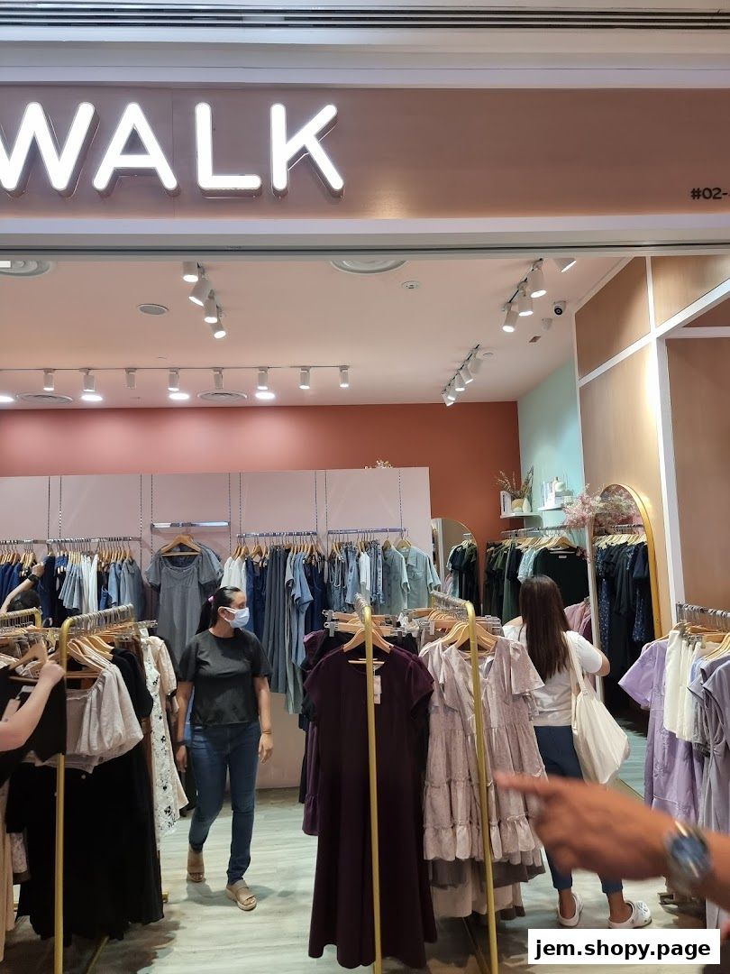The Stage Walk clothing store interior with racks of women's apparel and shoppers.