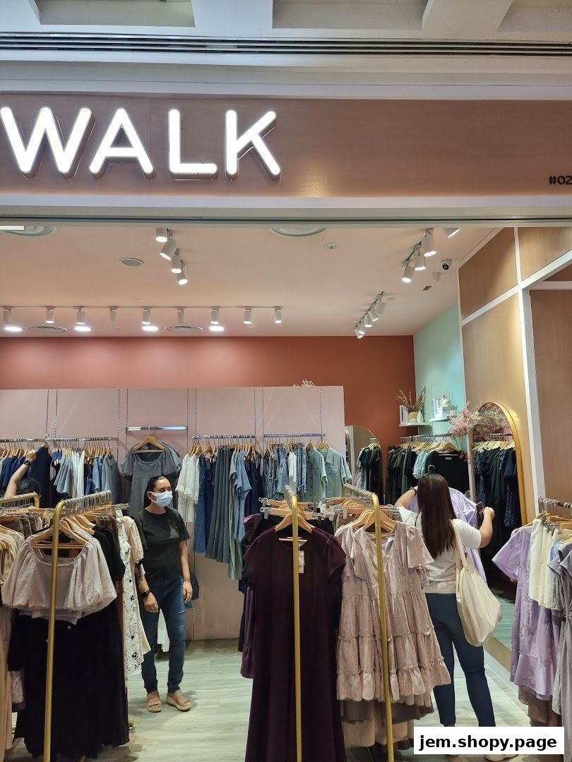 The entrance of 'The Stage Walk' clothing store, showcasing racks of stylish apparel.