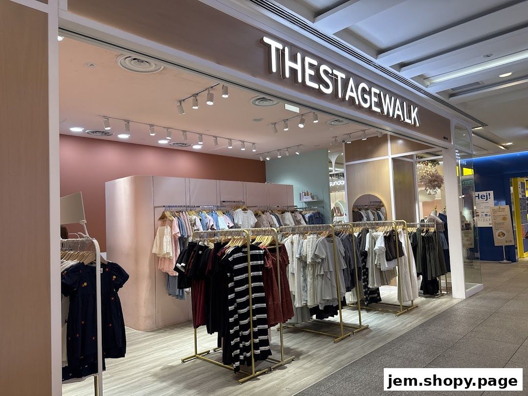 The Stage Walk clothing store entrance with racks of apparel and a prominent sign.