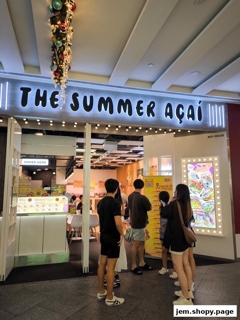 The Summer Açaí shop front with customers queuing and a festive garland overhead.