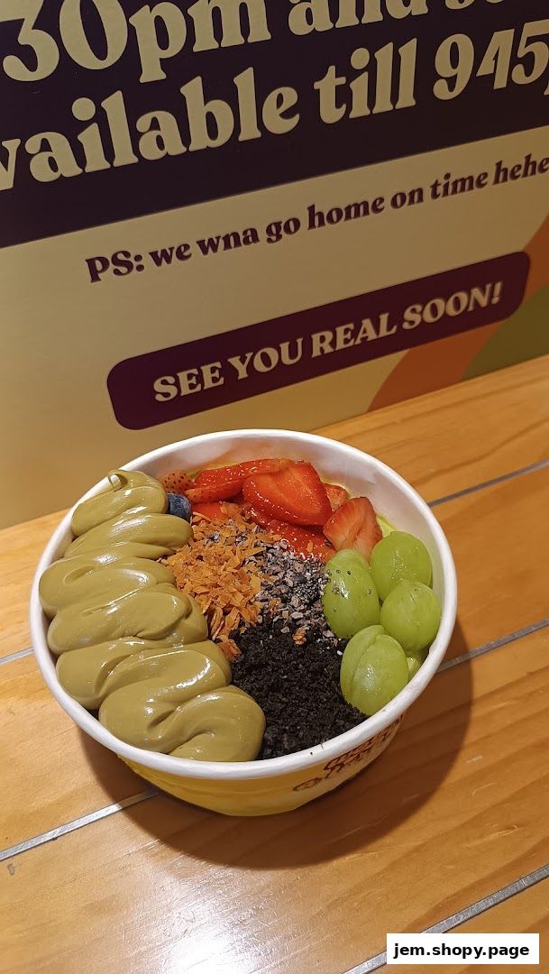 A delicious acai bowl topped with matcha, strawberries, grapes, and granola.