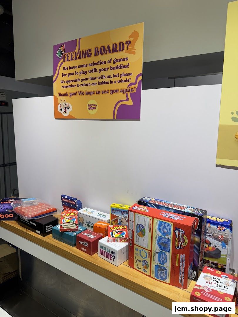 A display of various board games and card games on a shelf, with a sign above.