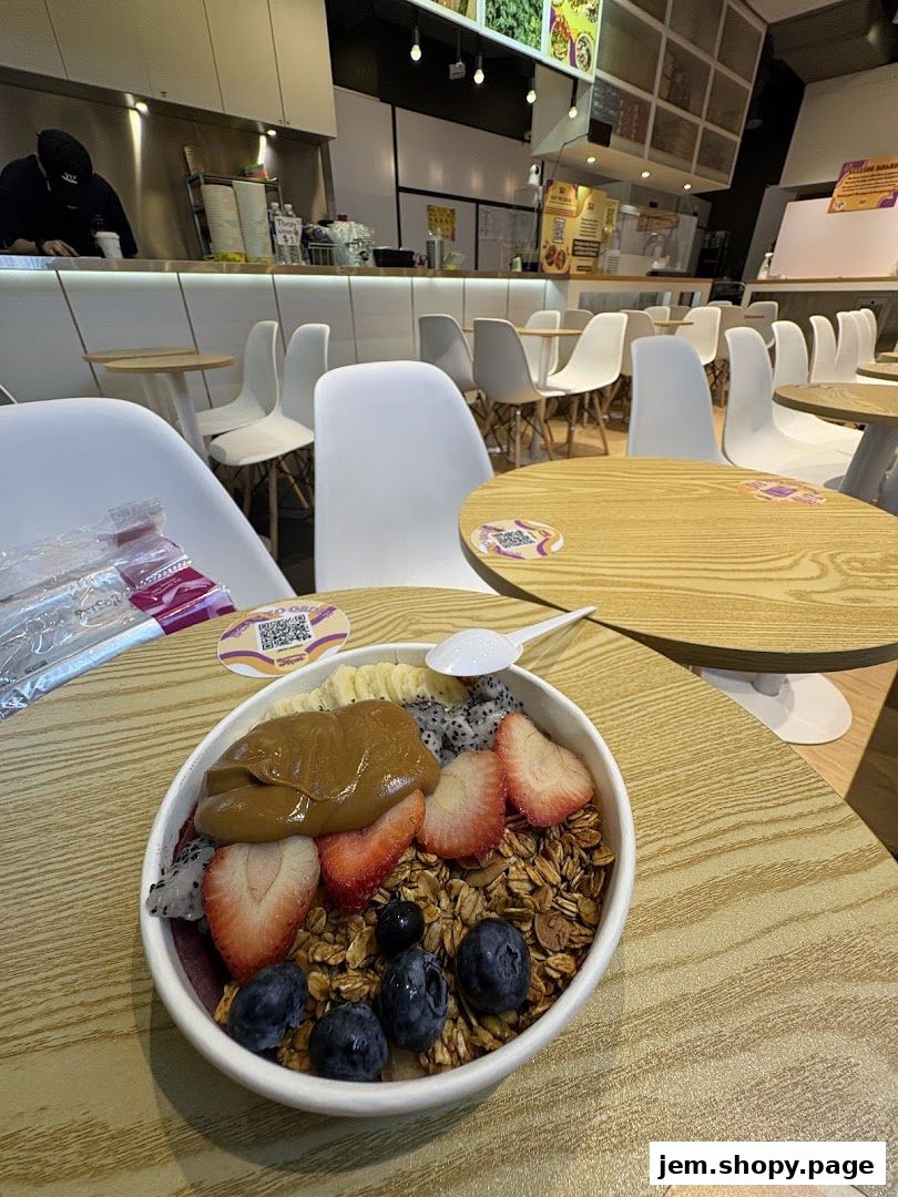 A delicious açaí bowl with fruits and granola on a wooden table.