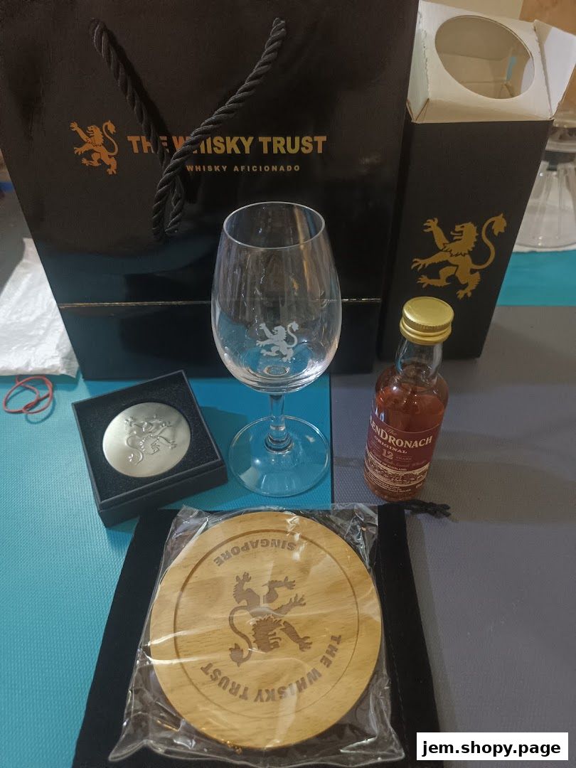 A collection of whisky-related items including a glass, miniature bottle, coaster, and bag.