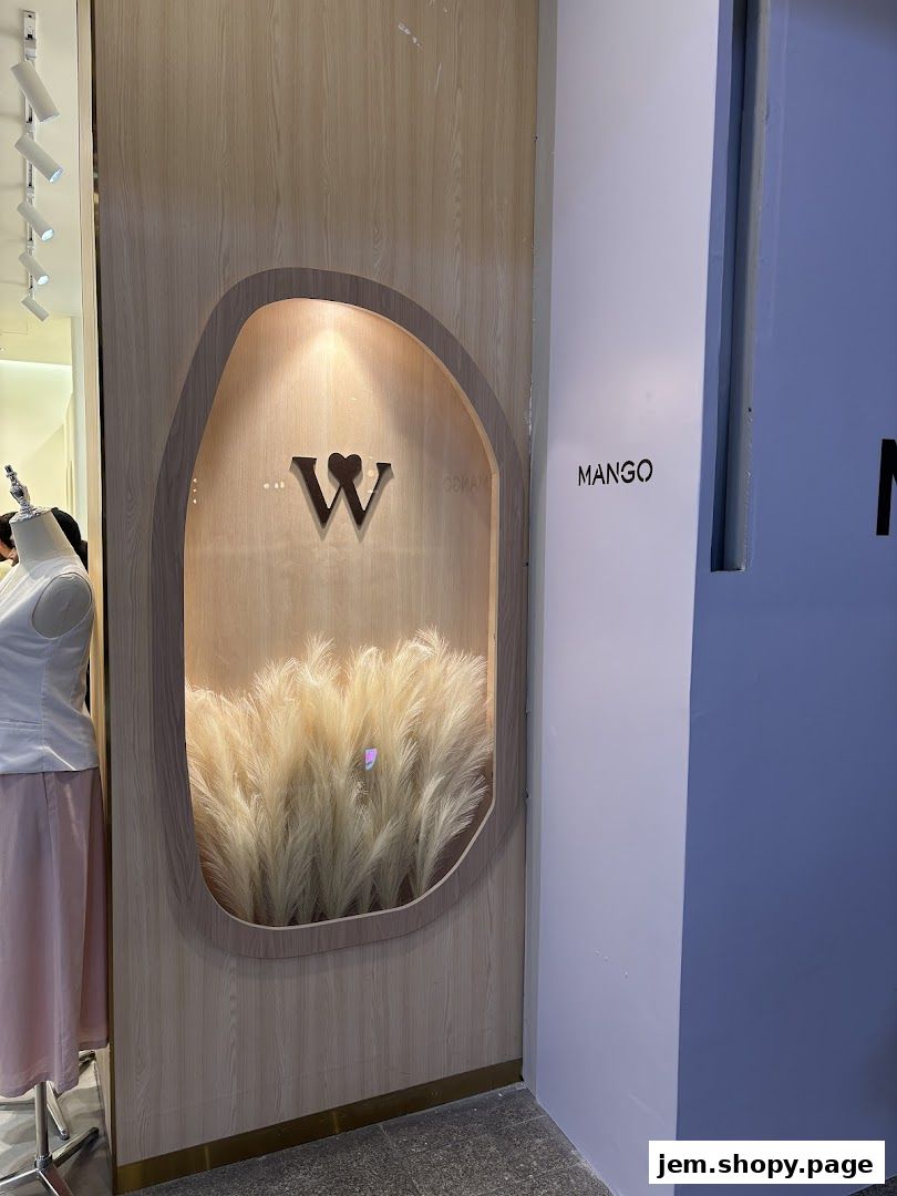 Shop entrance with a 'W' logo and dried grass display, next to a 'MANGO' sign.
