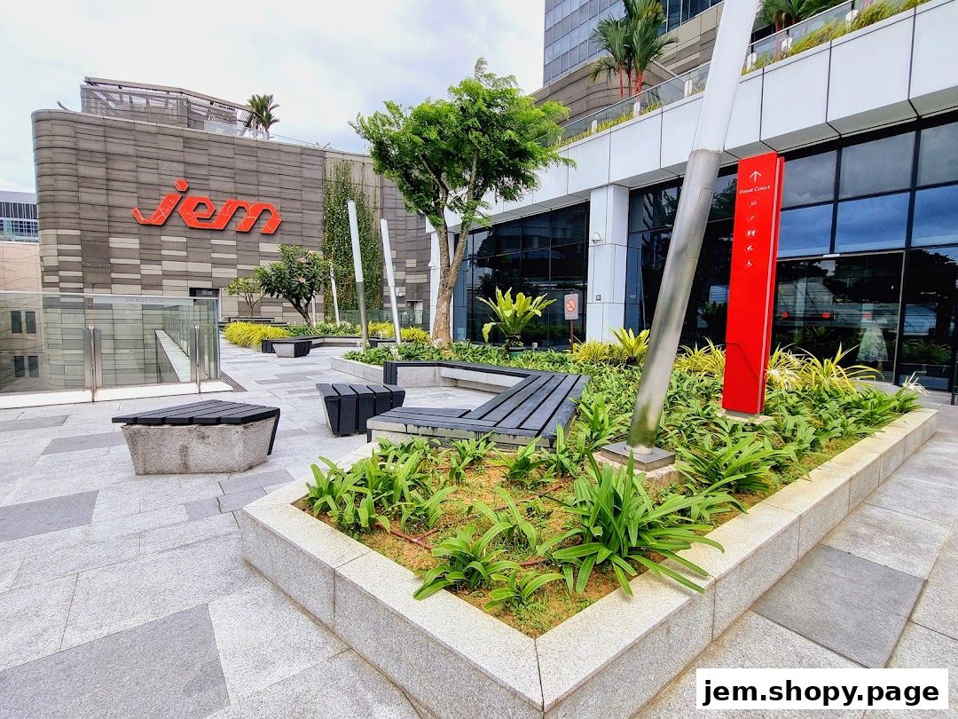 Outdoor seating area with greenery and signage for 'Jem' and 'Food Court'.
