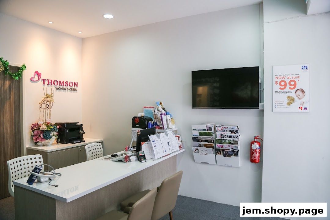Reception area of Thomson Women's Clinic with a counter, seating, and health-related posters.