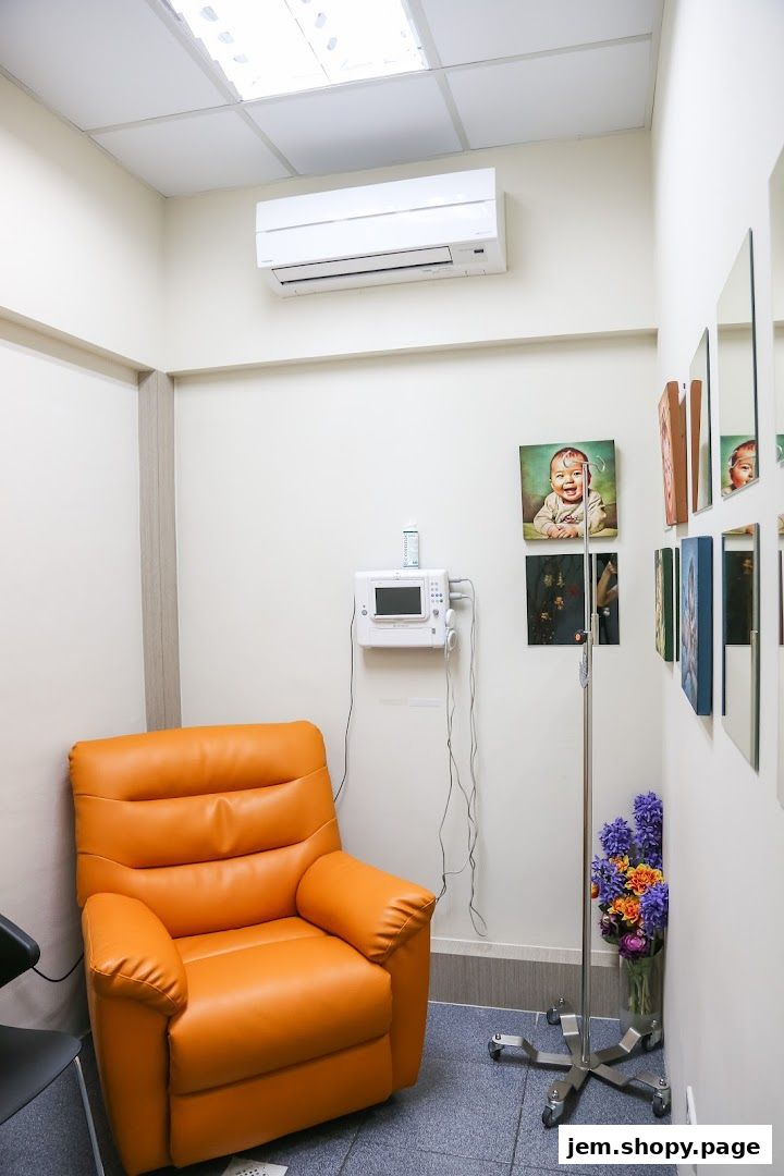 A comfortable orange recliner chair in a medical consultation room with artwork on the wall.