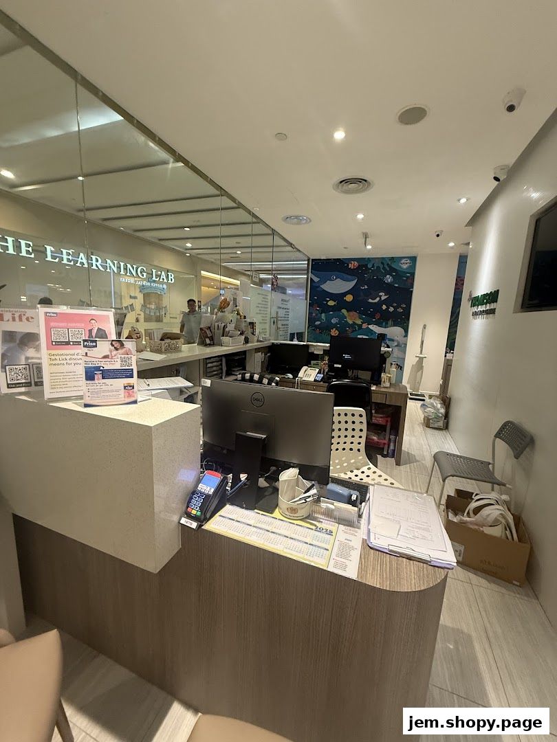 Reception area of Thomson Womens Clinic with a counter, computer, and wall art.