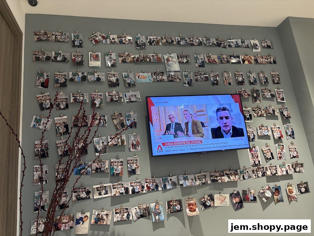 A wall decorated with numerous photos and a television screen displaying news.