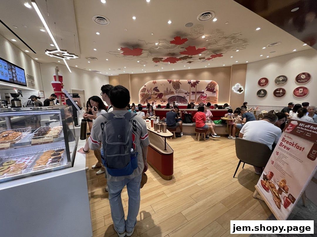 Interior of a busy Tim Hortons with customers ordering and dining.