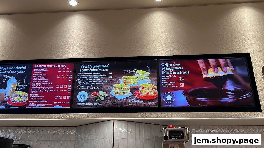 A digital menu board displaying coffee, tea, sourdough melts, and holiday gift boxes.