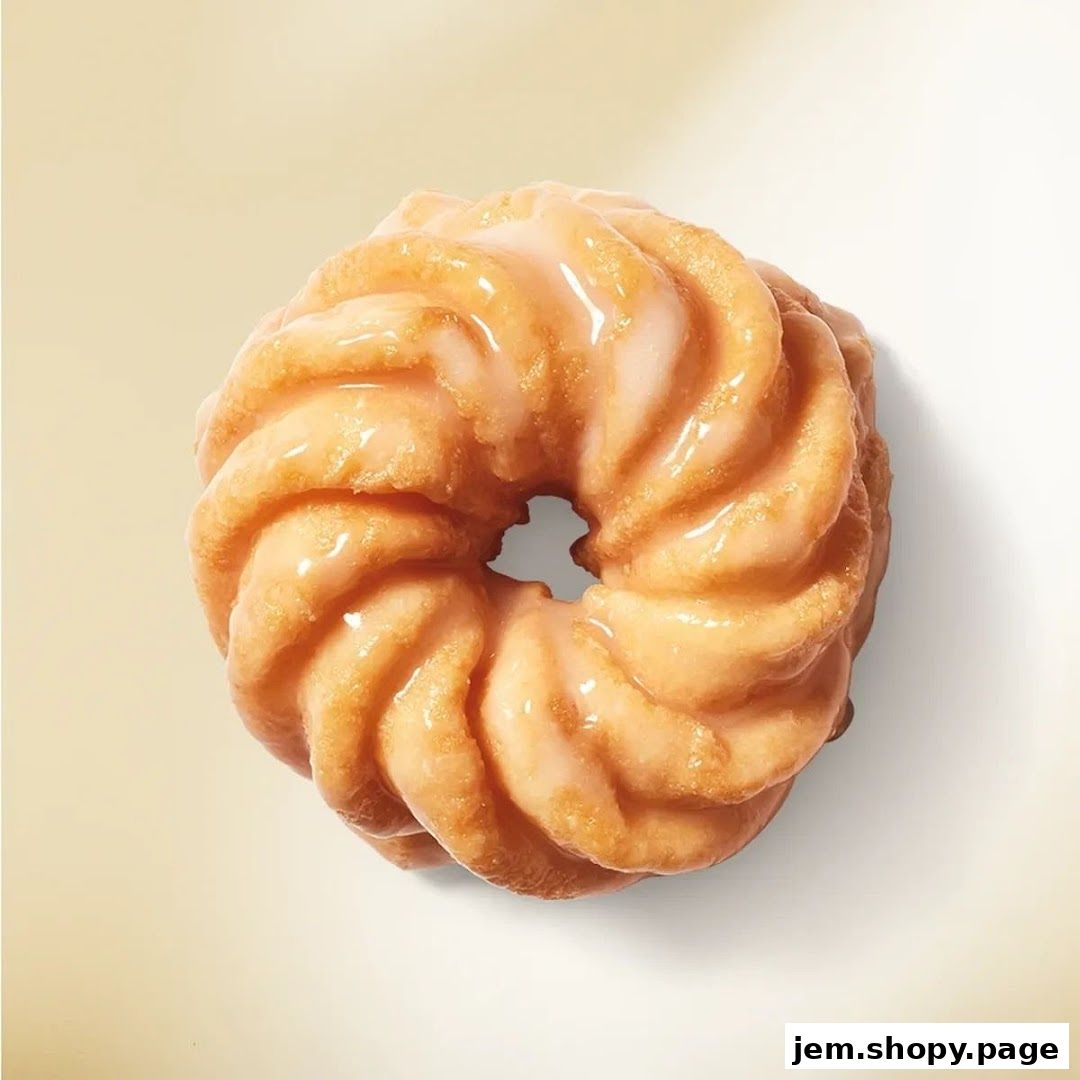 A close-up shot of a glazed, fluted donut on a light background.