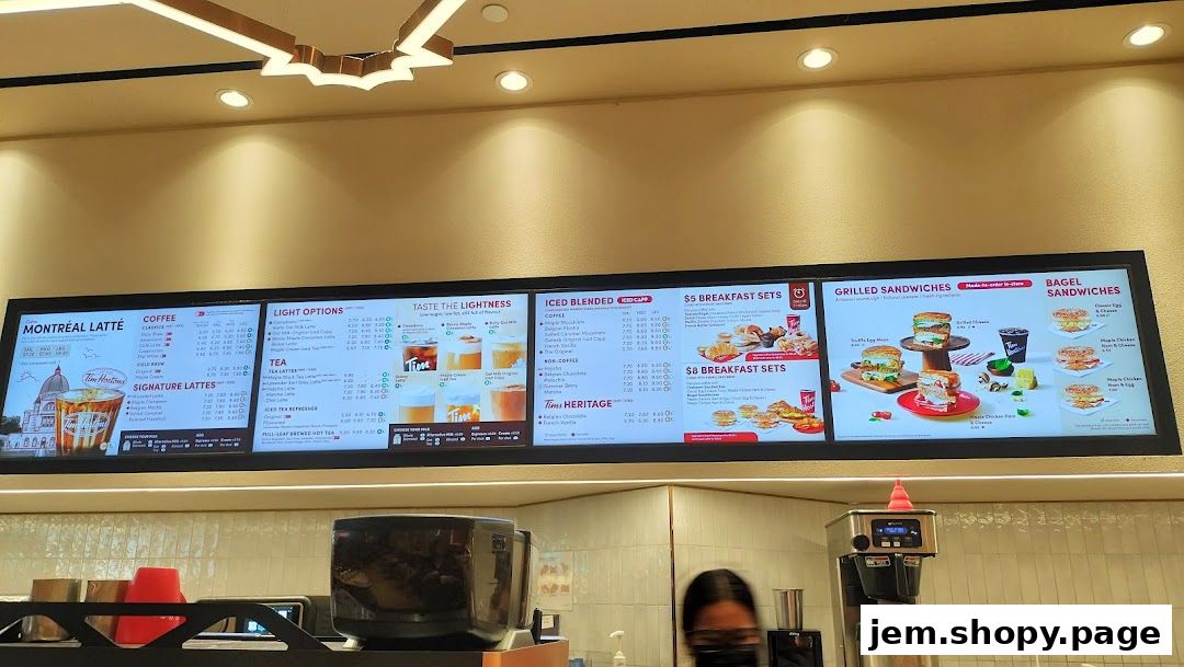 A digital menu board displaying coffee, tea, breakfast sets, and sandwiches at Tim Hortons.