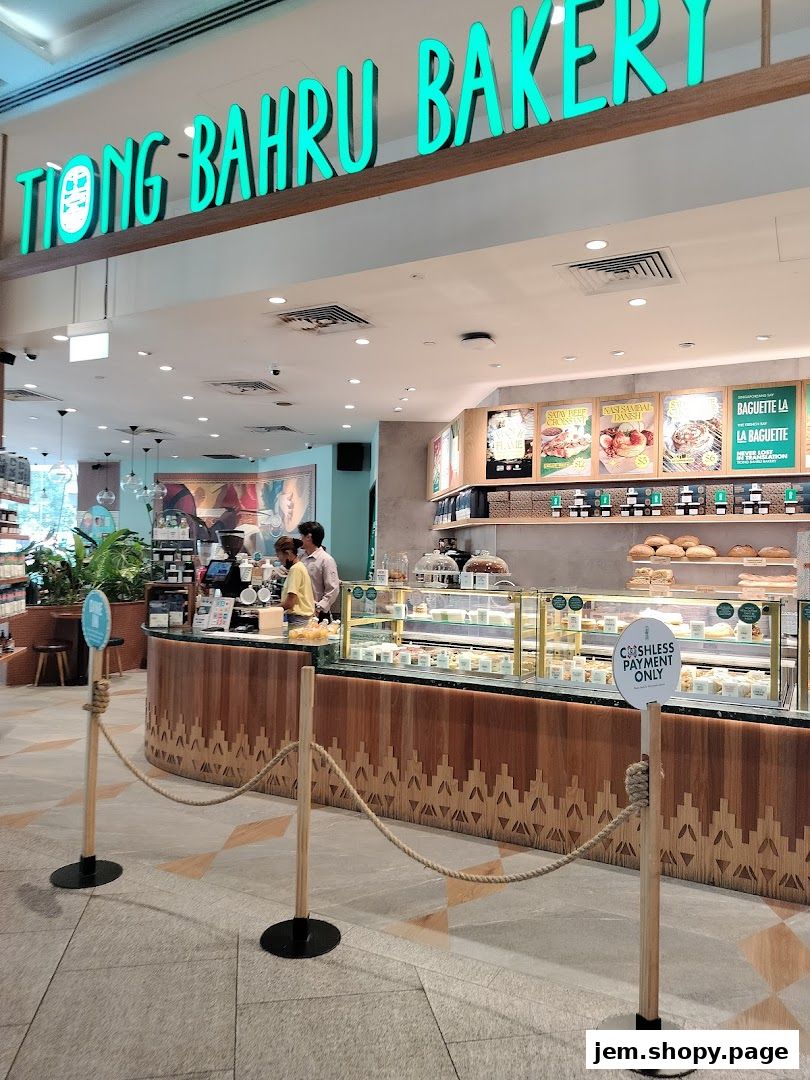 The entrance of Tiong Bahru Bakery with a display of pastries and a sign indicating cashless payment.