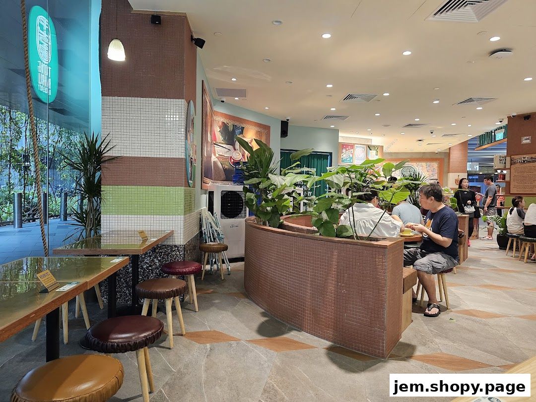 Interior view of Tiong Bahru Bakery with patrons dining and lush greenery.