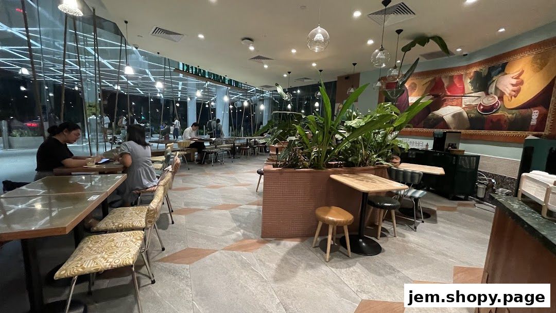 Interior of Tiong Bahru Bakery with patrons seated at tables and lush greenery.
