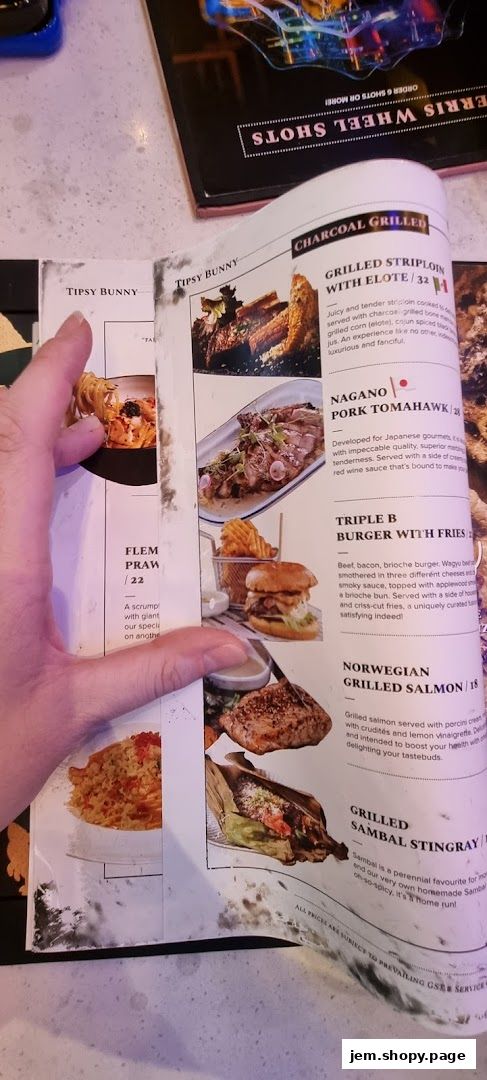 A person's hand holding open a menu from Tipsy Bunny, showcasing various dishes.