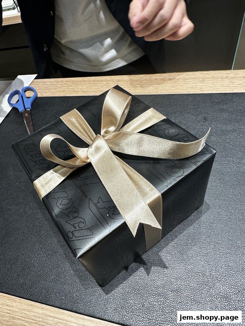 A Tissot branded gift box wrapped in black paper with a gold ribbon.