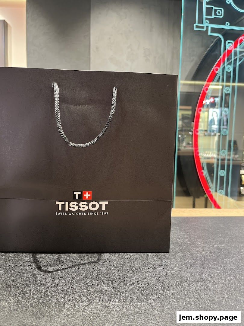 A black Tissot shopping bag with silver handles and the Tissot logo.