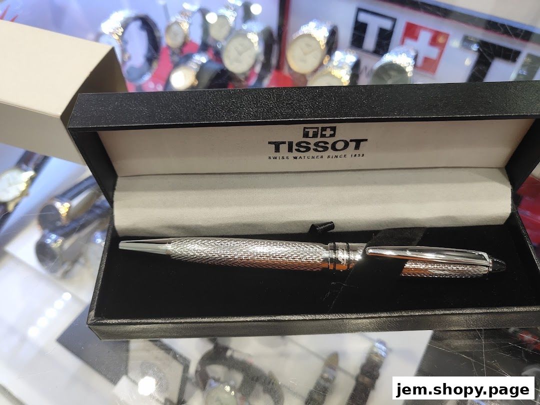 A Tissot branded pen displayed in its gift box, with watches in the background.