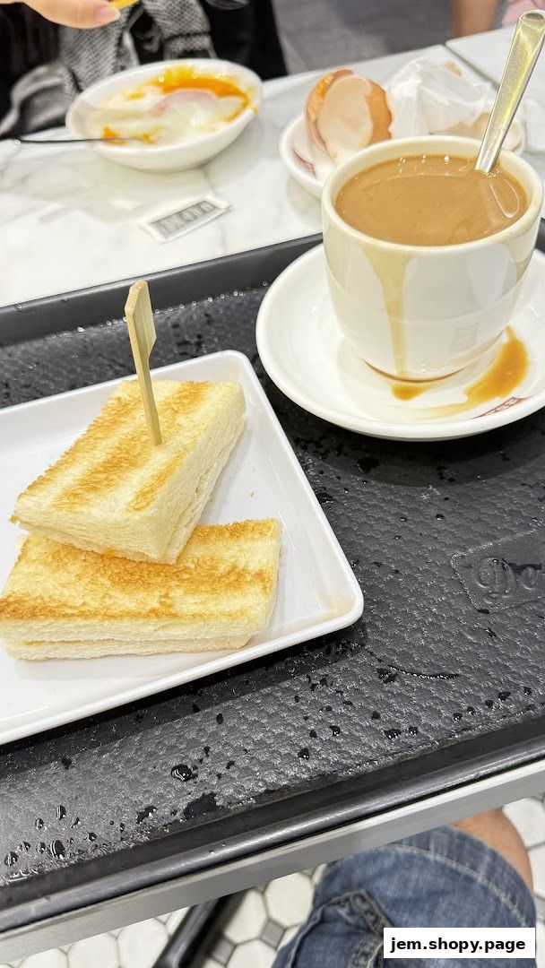 A tray with toast, soft-boiled eggs, and a cup of coffee from Toast Box.
