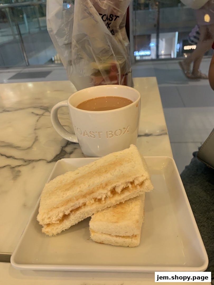 A cup of coffee and toast with peanut butter on a white plate.