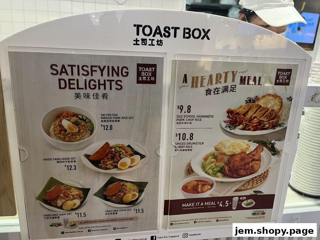 A menu board for Toast Box showcasing various rice and noodle sets with prices.