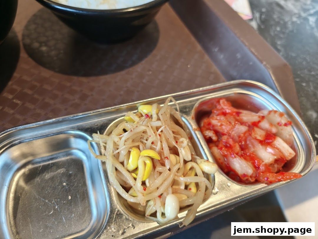 A close-up of Korean side dishes, including kimchi and seasoned bean sprouts.