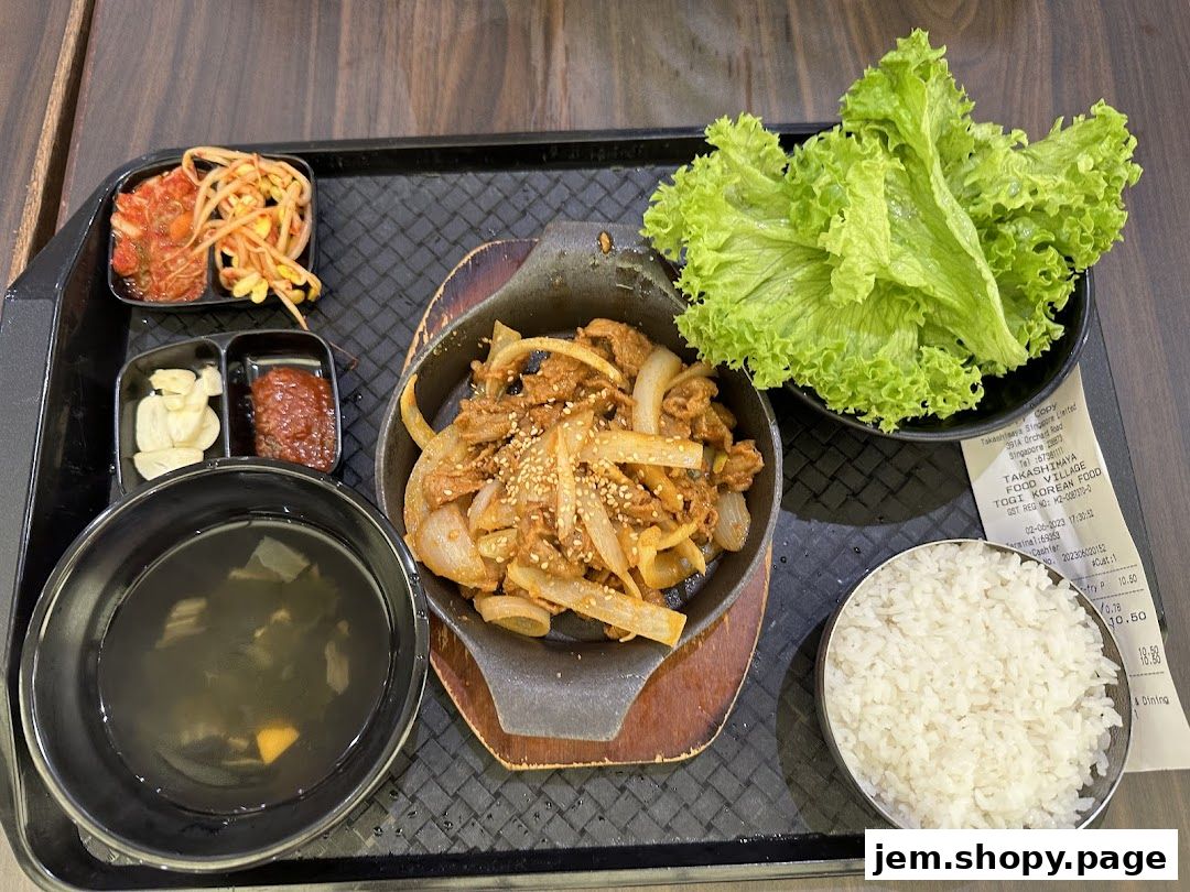 A Korean meal set with bulgogi, rice, soup, kimchi, and lettuce wraps.