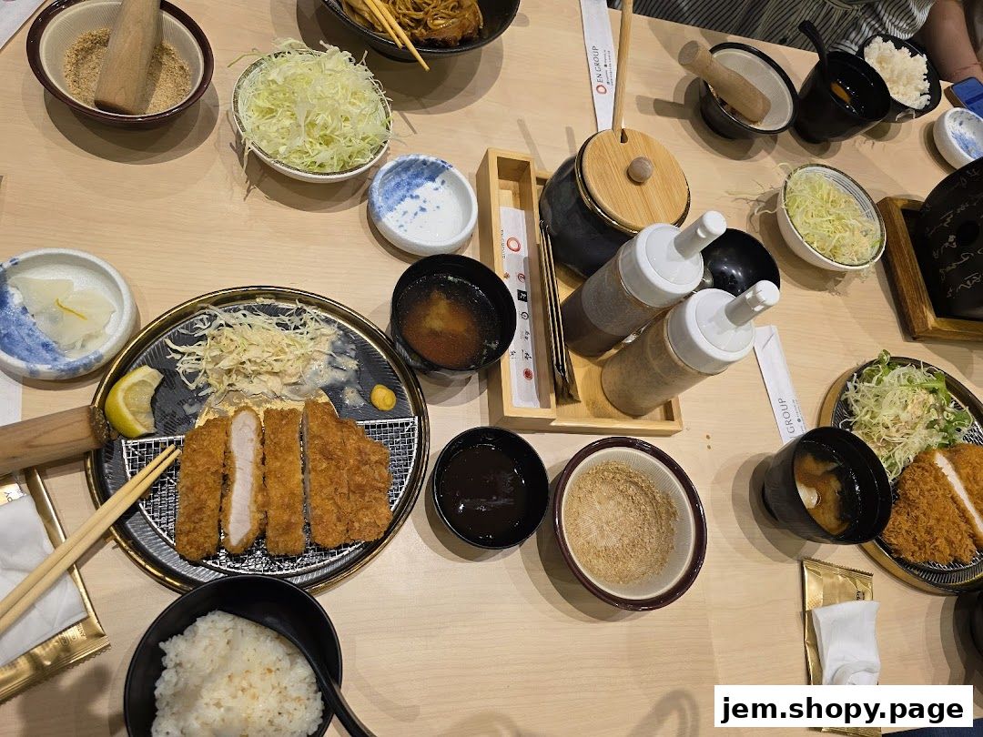 A table laden with delicious Tonkatsu ENbiton Jem meals, featuring crispy pork cutlets, rice, and sides.
