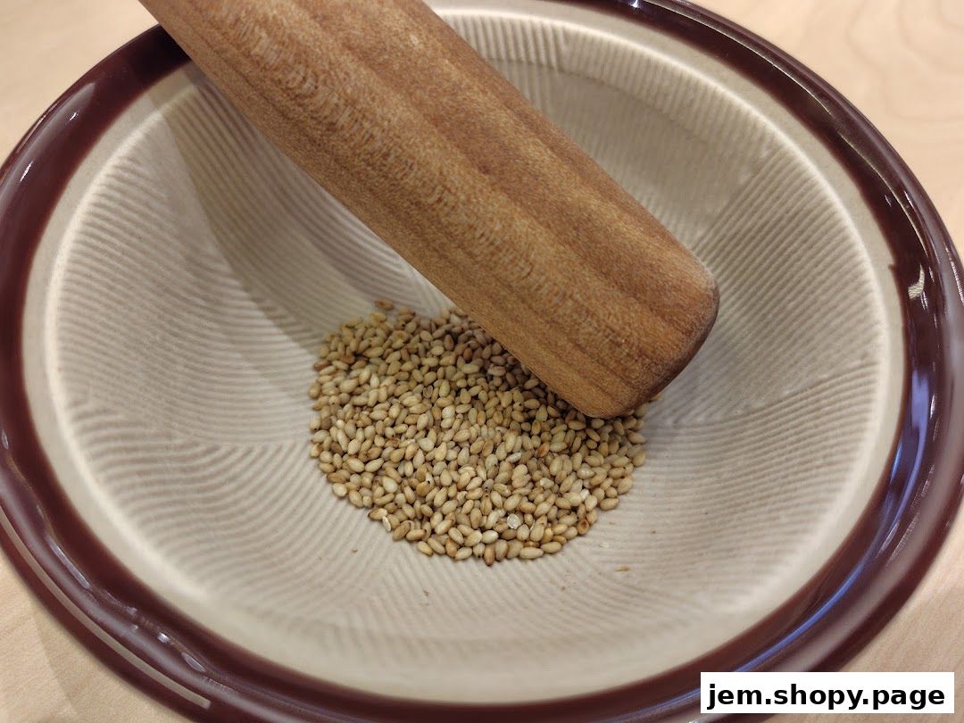 A mortar and pestle with sesame seeds inside, ready for grinding.
