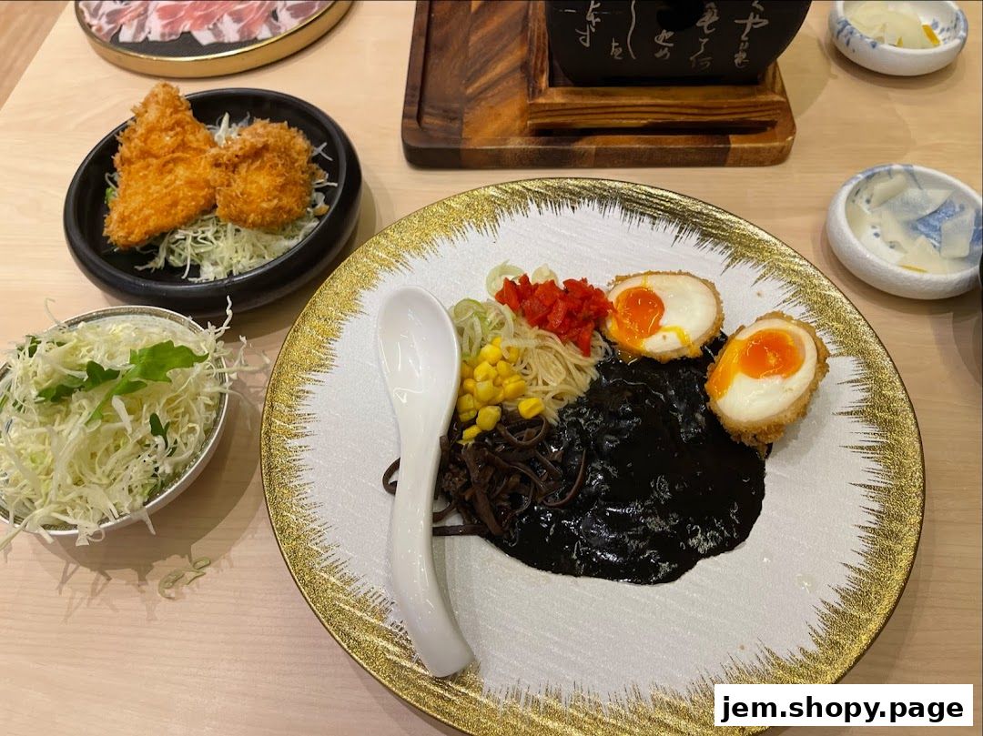 A plate of black ramen with fried eggs, corn, and shredded cabbage.