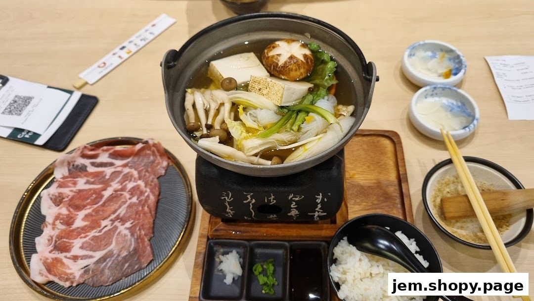 A hot pot dish with thinly sliced meat, rice, and dipping sauces.