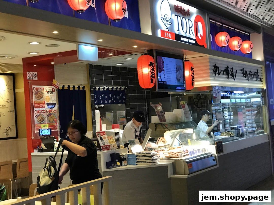 A TORI-Q Japanese Yakitori shop with staff preparing food and a menu displayed.