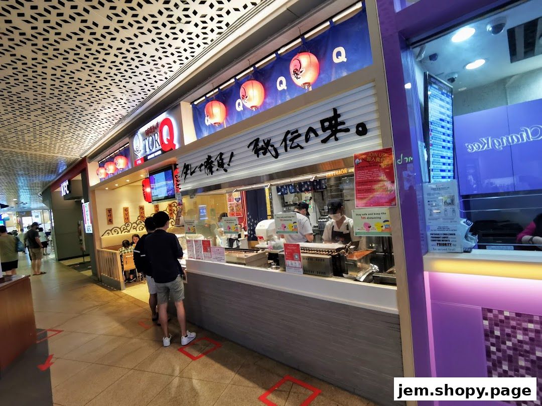 A TORI-Q shop front with staff preparing food and customers queuing.