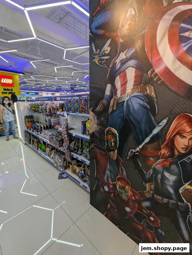 Interior view of a Toys R Us store with shelves of toys and a large Marvel superhero mural.