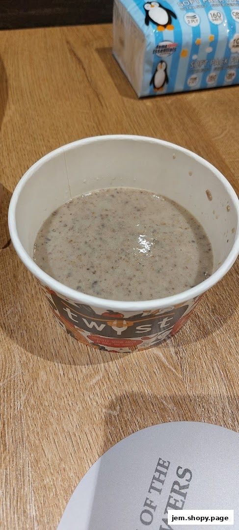 A cup of creamy mushroom soup from Twyst, with a napkin pack in the background.