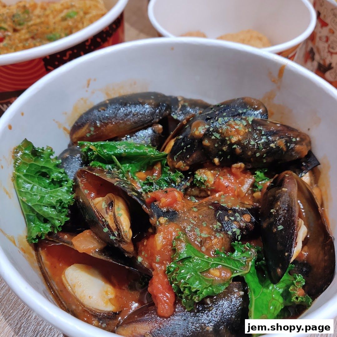A close-up of a bowl of mussels in tomato sauce with kale, garnished with herbs.