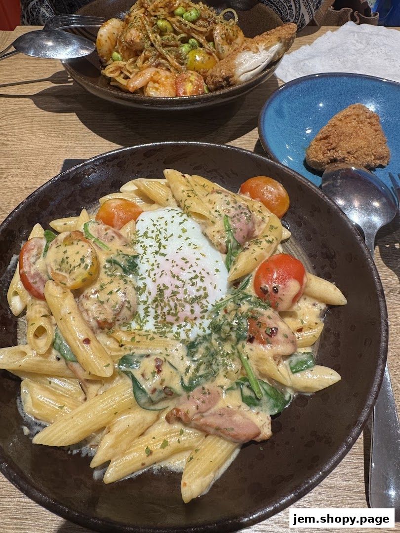 Two delicious pasta dishes and a fried appetizer are presented on a wooden table.