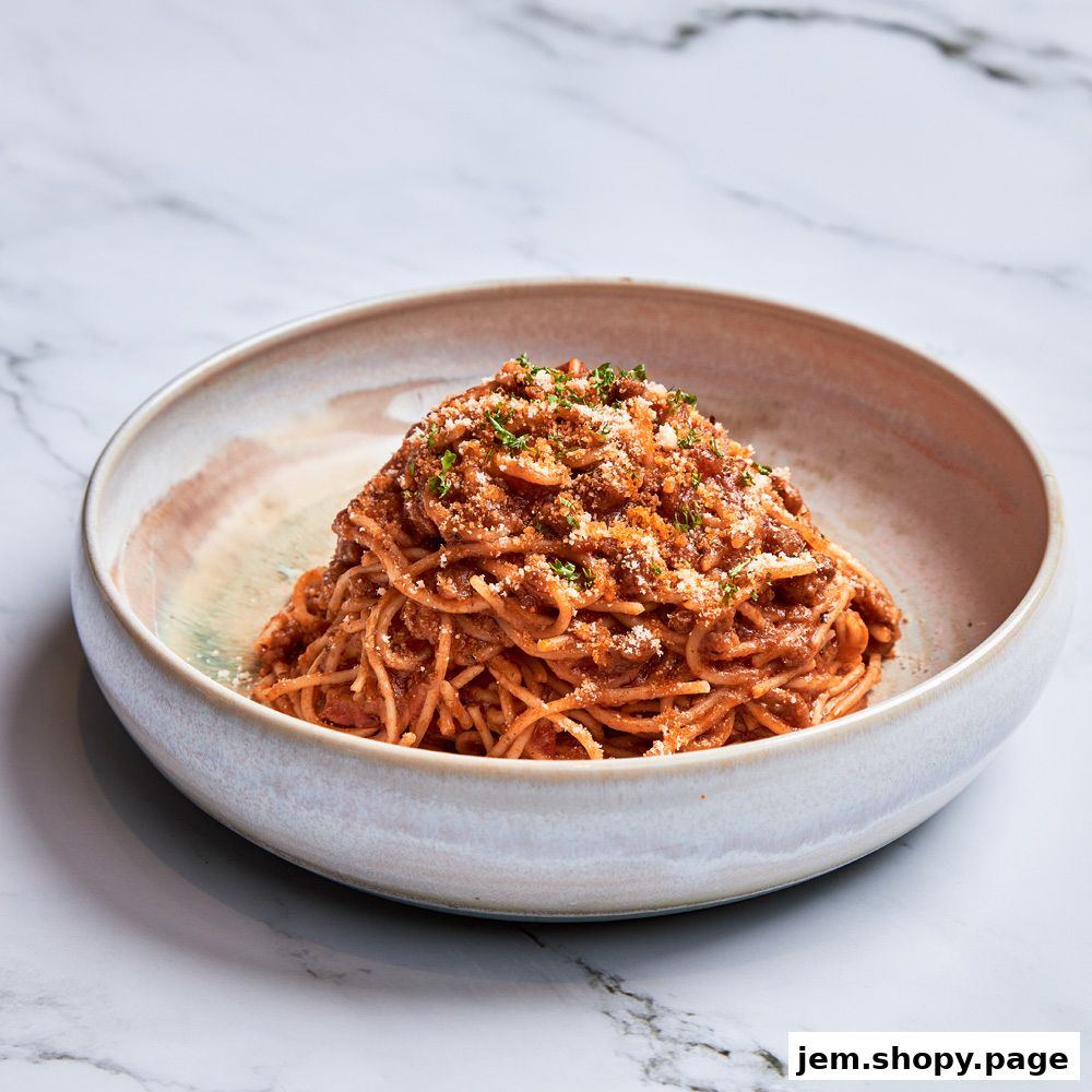 A close-up shot of a bowl of spaghetti with meat sauce and grated cheese.