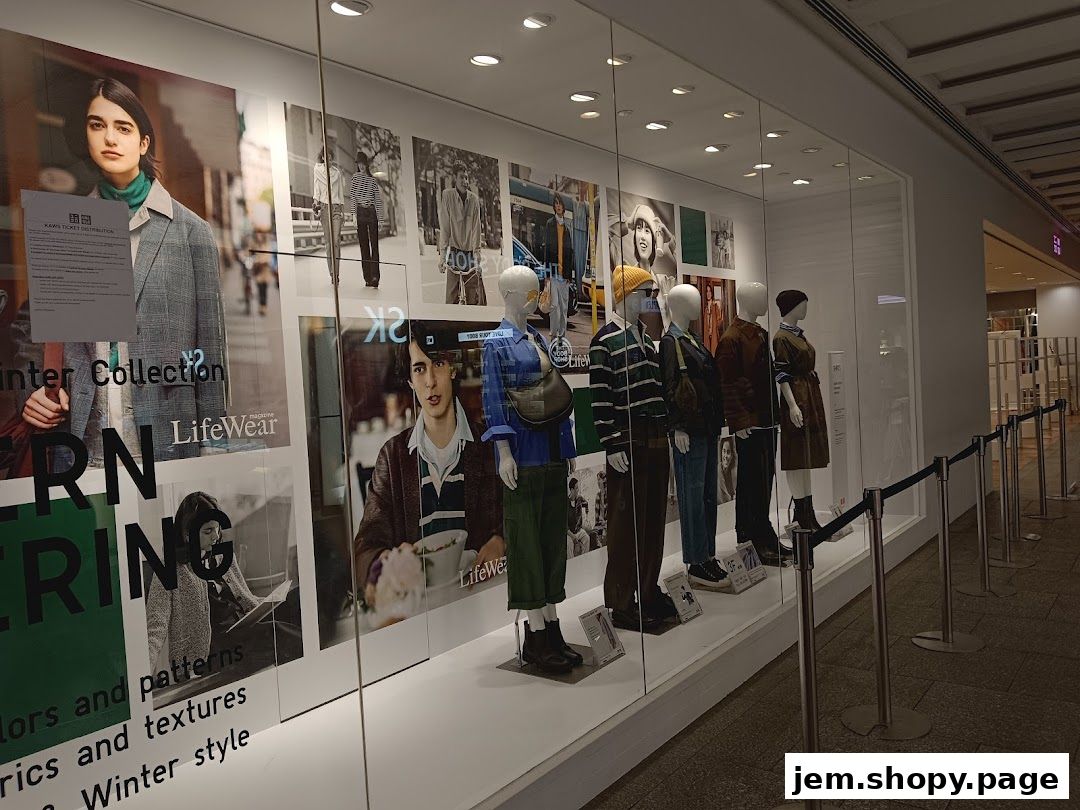 UNIQLO store window display featuring mannequins in winter collection outfits and promotional posters.