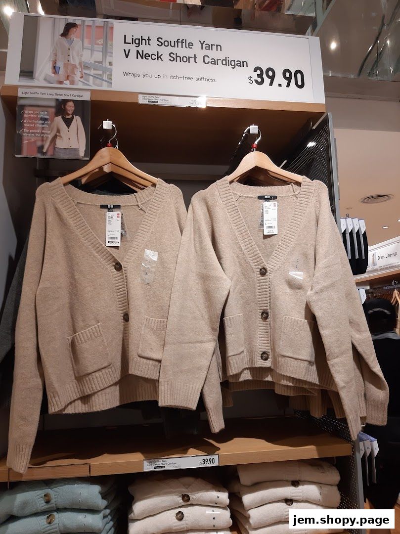 UNIQLO display featuring beige V-neck short cardigans and stacked folded sweaters.