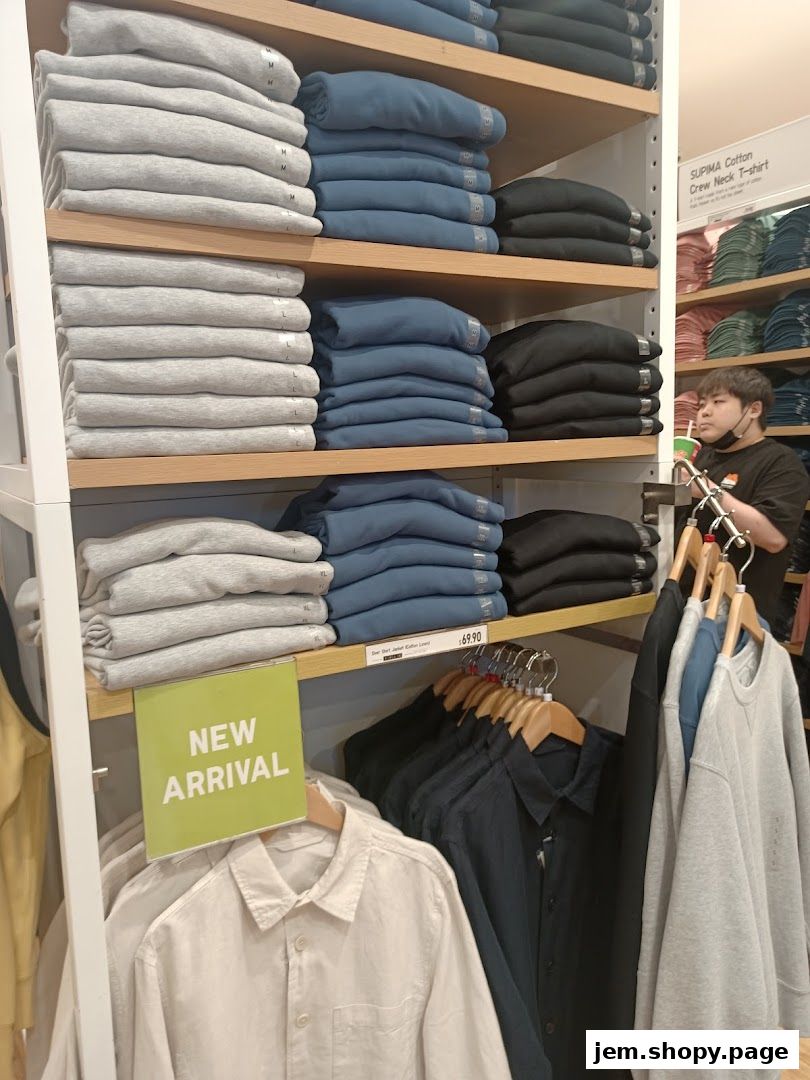 Neatly folded sweaters and shirts displayed on shelves and racks in a retail store.
