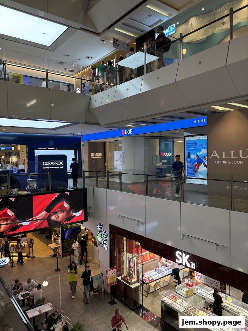 Interior view of a multi-level shopping mall with various shops and escalators.
